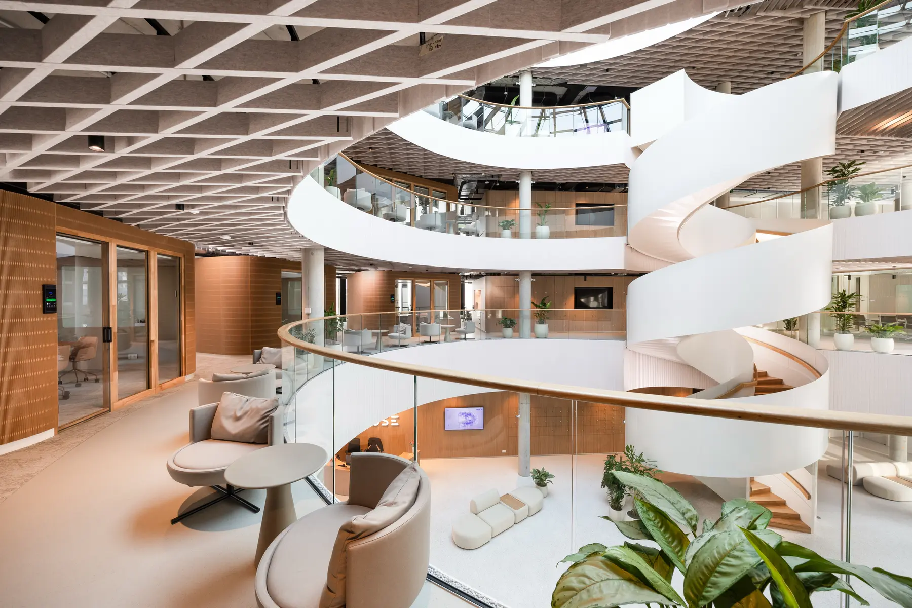 Interior of the Innovatrics workplace with an open atrium and curved staircase.