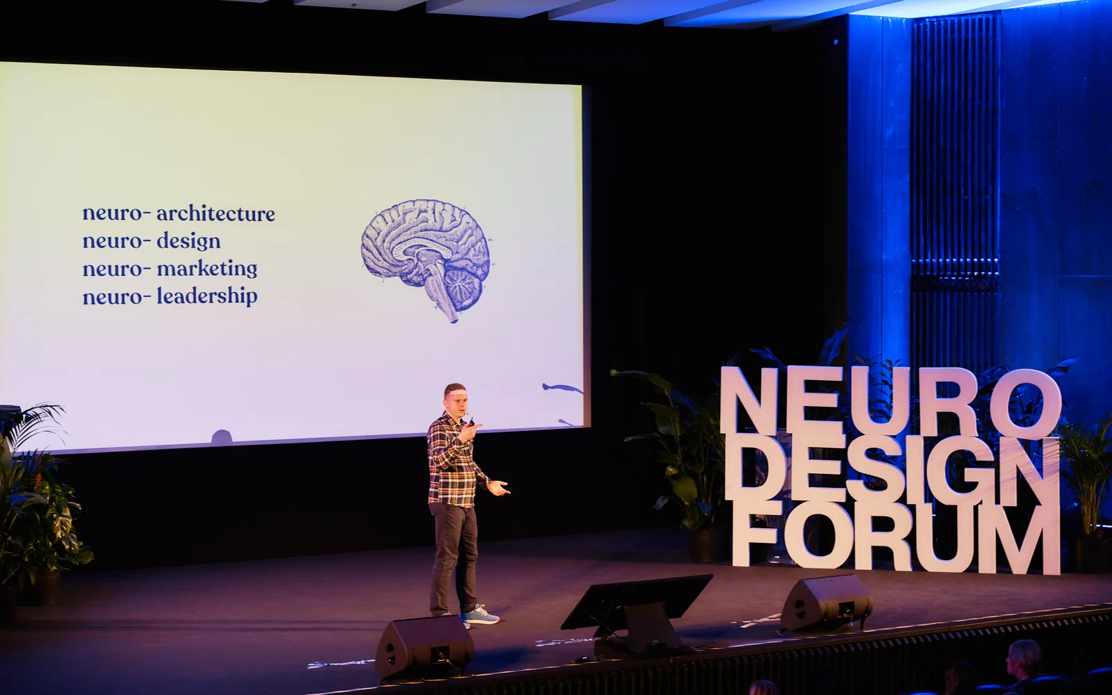 Michal Matlon speaking onstage at Neuro Design Forum.